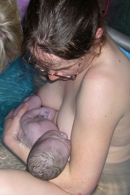 mother breastfeeding baby in birthing pool